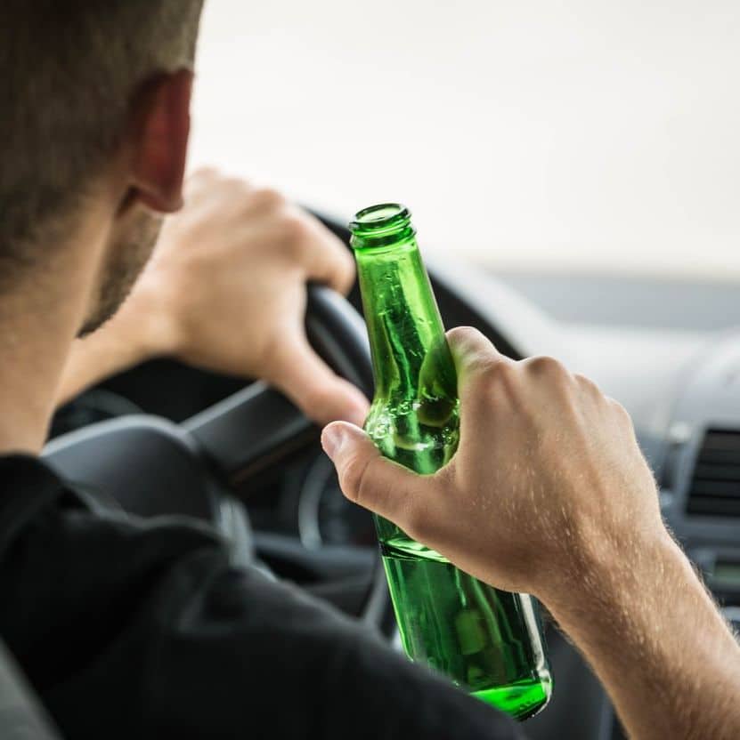 Man drinking beer while driving